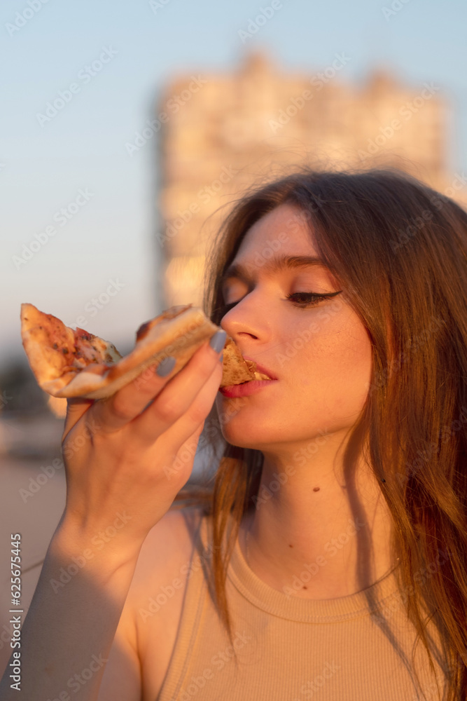 Young woman eating pizza on the street Young woman eating pizza on the street