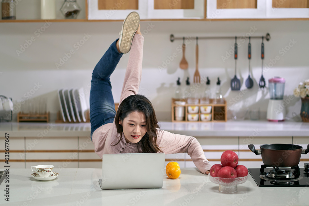 young asian stretching legs while working at home using laptop young asian stretching legs while working at home using laptop