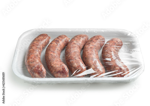 Raw pork sausages in plastic packaging on white background