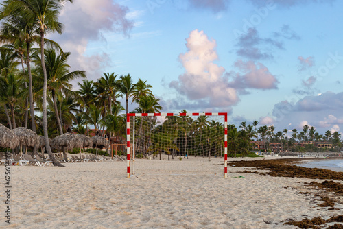 but en métal sur une plage en bord d'océan avec la lumière d'un lever de soleil et des nuages à l'horizon avec des palmiers en arrière plan © Veronique