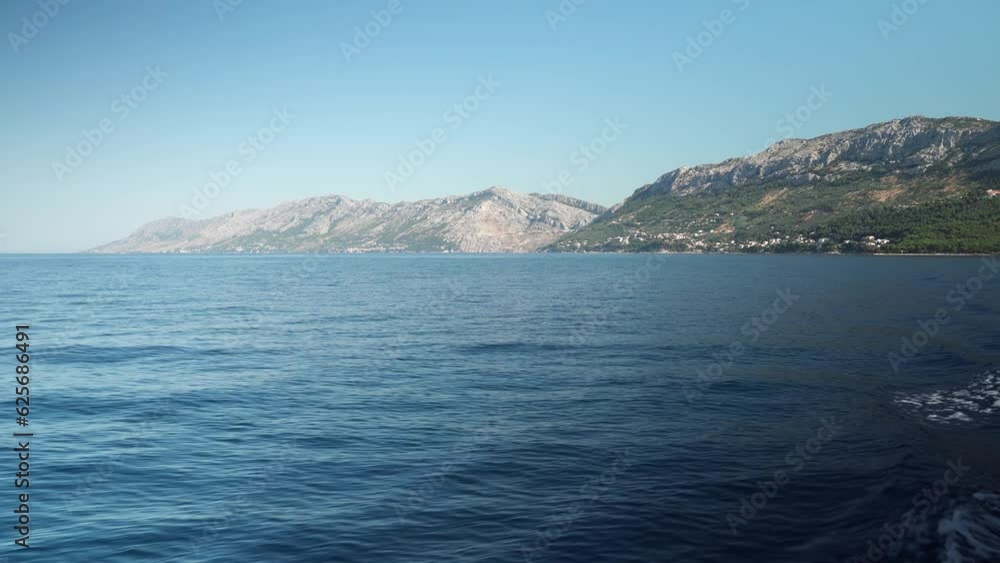 The ship sails from the pier in the port of the Adriatic Sea in the village of Brela Croatia.Yacht cruise on the Croatian Adriatic Sea. The resort village of Brela on the Adriatic coast of Croatia The ship sails from the pier in the port of the Adriatic Sea in the village of Brela Croatia.Yacht cruise on the Croatian Adriatic Sea. The resort village of Brela on the Adriatic coast of Croatia