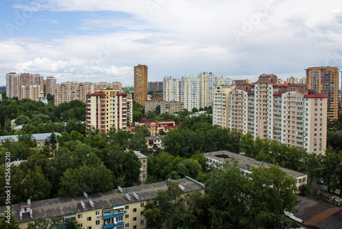 Panoramic top view of the city of Reutov in the Moscow region with tall modern houses among the lush green foliage of trees on a clear summer day