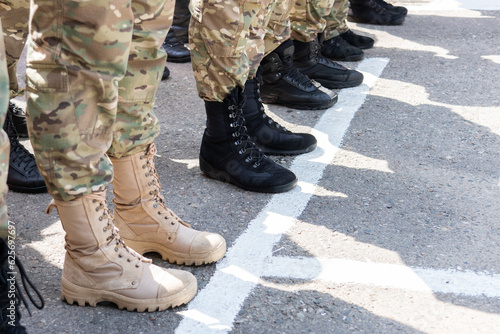 The soldiers are in line. Military uniform and footwear. The legs of the military in the ranks.