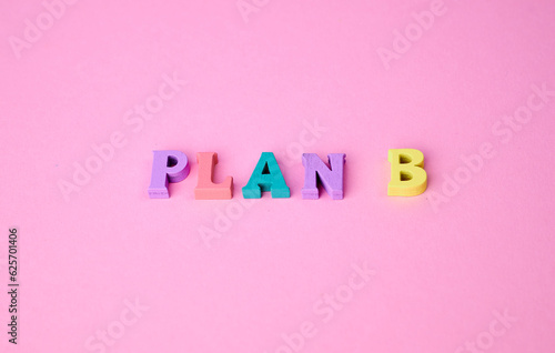 the expression plan B laid with colorful wooden letters on pink background