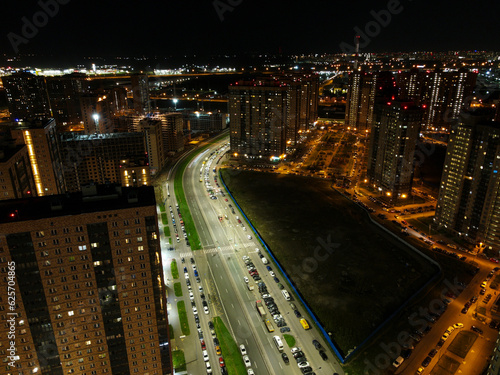 Aerial view of a residential high-rise buildings and constructing more next to highway and forest in the historical and at same time modern city of St. Petersburg at sunny summer night
