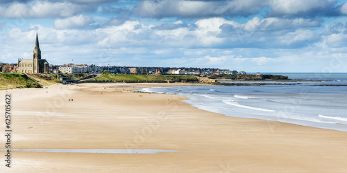 Long Sands beach at Tynemouth on a bright spring day, with St George's church at Cullercoats in the distance, Tyne and Wear.	 photo