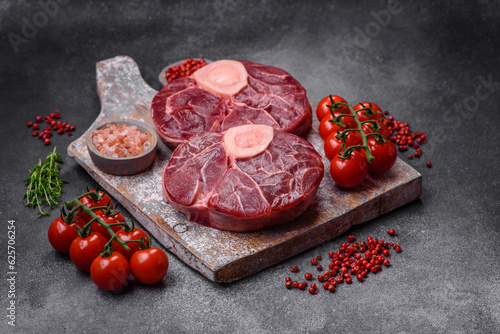 Fresh raw beef steak with bone or ossobuco with salt, spices and herbs