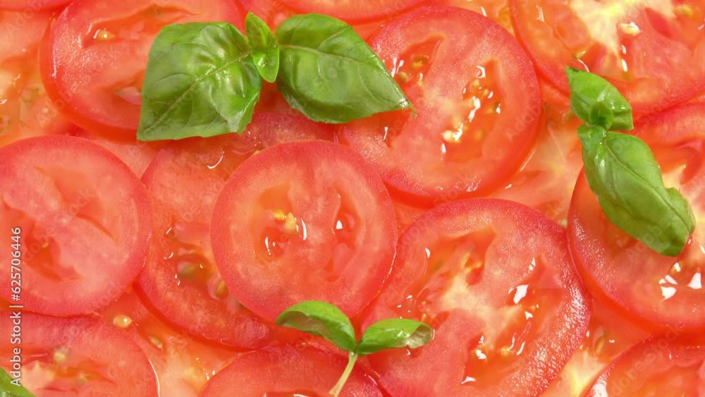 Sliced fresh tomatoes with fresh basil leaves like tomato carpaccio rotate as background. Preparations for pizza or vegetable salad. Tomato slices close up Sliced fresh tomatoes with fresh basil leaves like tomato carpaccio rotate as background. Preparations for pizza or vegetable salad. Tomato slices close up