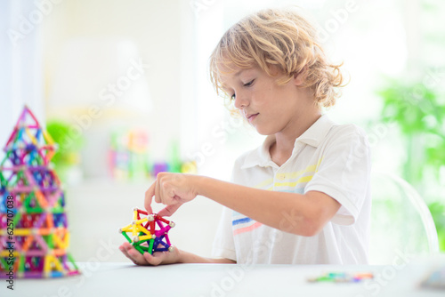 Child playing with magnetic building blocks.