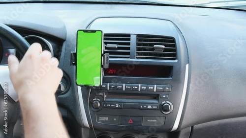 Inside black sports car vertical smartphone mock-up greenscreen device attached to auto dashboard. Close-up. Sunset in background.