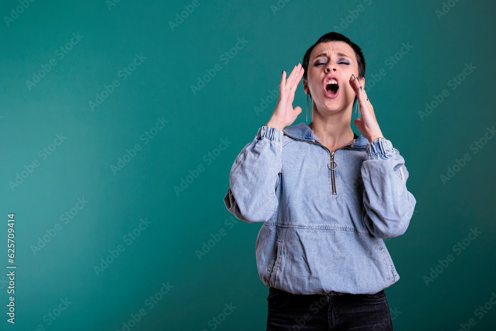Portrait of angry unhappy woman having agressive emotion screeming while posing in studio standing over isolated background. Stressed worried caucasian female having mental breakdown