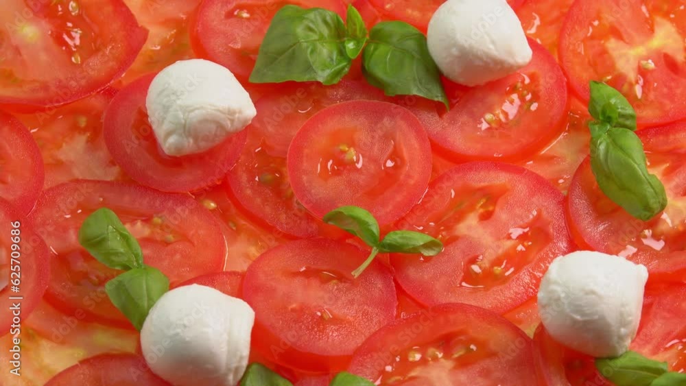 Sliced fresh tomatoes with fresh basil leaves and mozzarella balls for tomato carpaccio rotate as background. Preparations for pizza or vegetable salad. Tomato slices close up Sliced fresh tomatoes with fresh basil leaves and mozzarella balls for tomato carpaccio rotate as background. Preparations for pizza or vegetable salad. Tomato slices close up