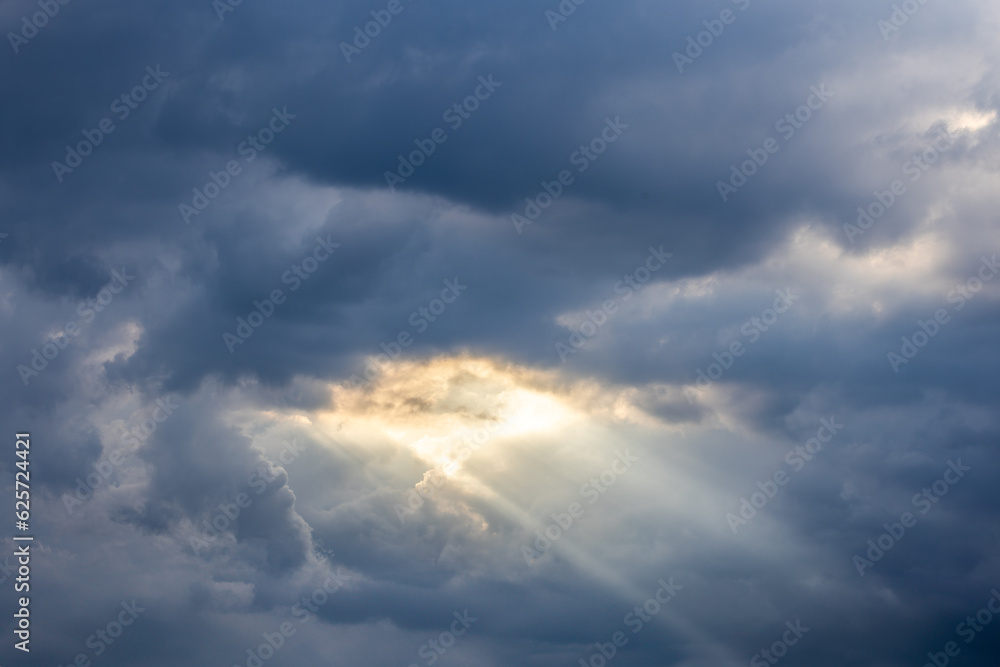 Obraz premium Sunrays through stormy clouds