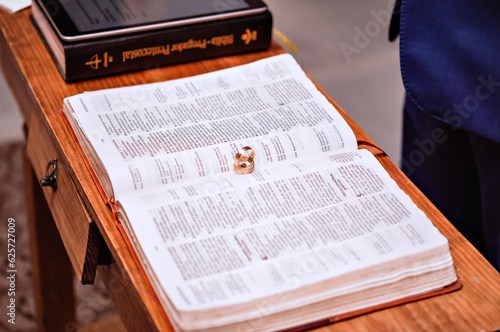 a pair of wedding rings on top of an open bible