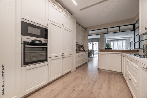 A spacious kitchen with walls covered in white wooden