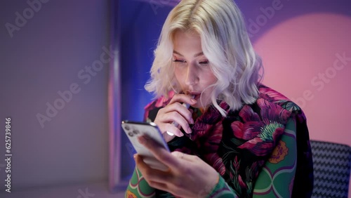 Portrait of cool stylish women browsing her mobile phone while smoking an electronic cigarette 