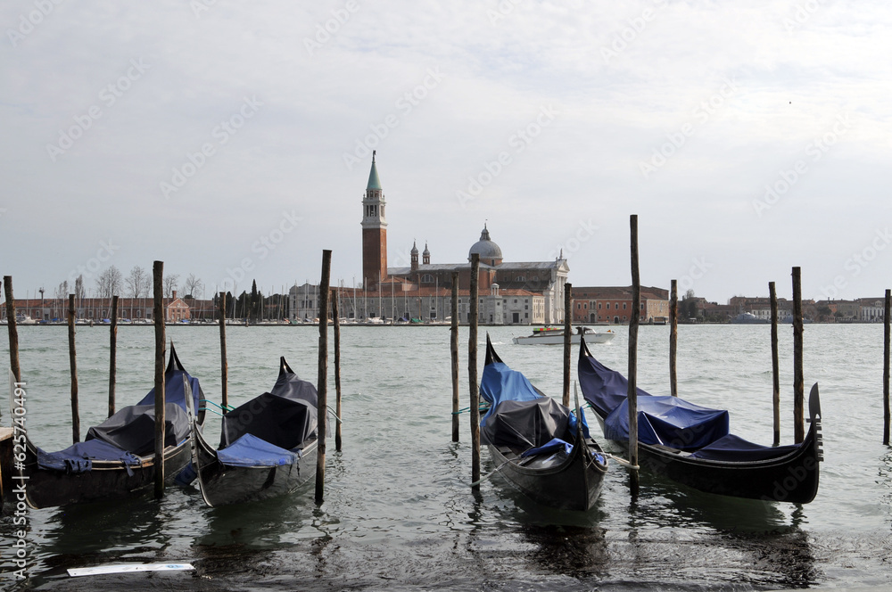 Gondolas And Wooden Pillars On The Grand Canal Near The Church Of San Giorgio Maggiore In Venice, Italy