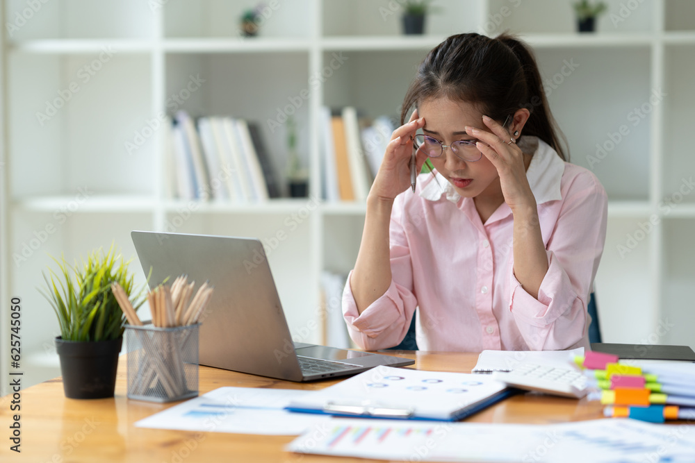Cropped image of asian businesswoman analyzing paperwork using laptop to actively search for information tense expressions at the office. Cropped image of asian businesswoman analyzing paperwork using laptop to actively search for information tense expressions at the office.