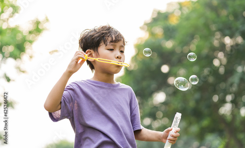 portrait of asian boy playing blowing bubbles © 1112000