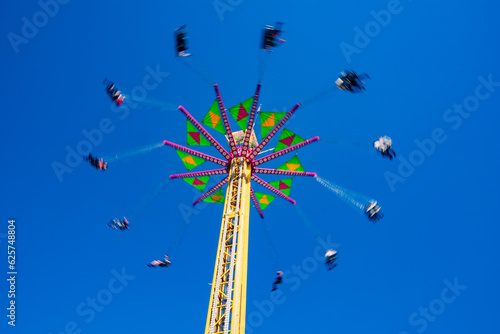 A ride spins in the blue sky at the North Carolina State Fair, Raleigh, North Carolina photo