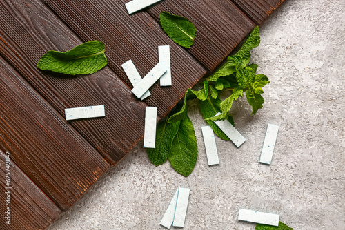 Fresh chewing gums with mint on wooden and grunge background
