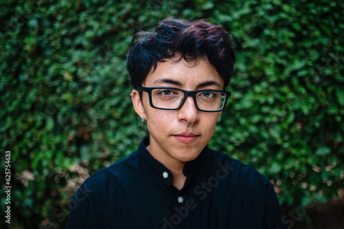 Close-up view of a transgender person posing on natural background.