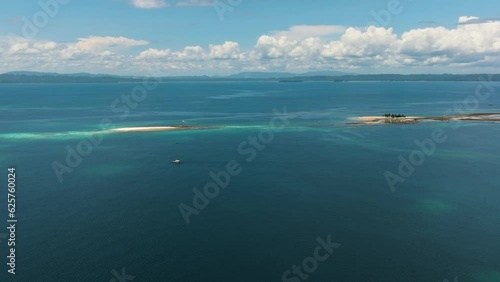 Aerial drone view of Hagonoy Island and Naked Island. Surrounded by deep blue sea under the blue skies. Mindanao, Philippines. photo