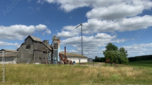 Wind turbine works near the old, dilapidated building. New technologies in godforsaken neighborhood. Past and future concept photo