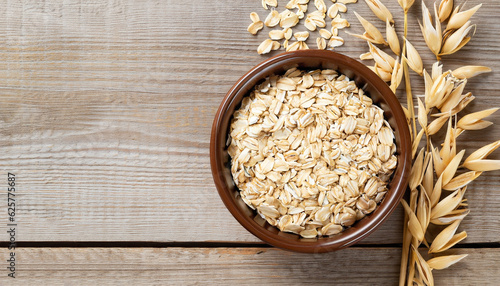 Tableau sur toile oat flakes in bowl and ears on wooden table top view