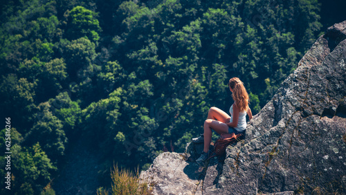 Woman sitting on rock enjoying forest in the mountain- calm, peaceful,wanderlust concept