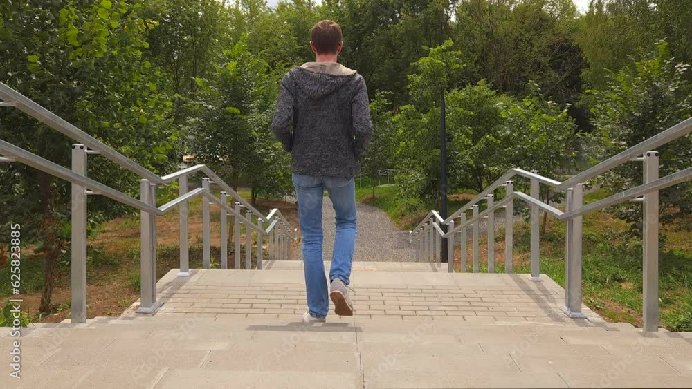 Man goes down stairs in city park Man goes down stairs in city park