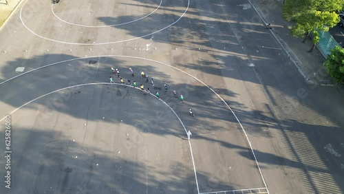 4K video footage aerial bird-eye view of a outdoor skating tracks. Kids are practicing roller skates training with coach on the small circuits in the sunset light. Concept for racing sports. photo