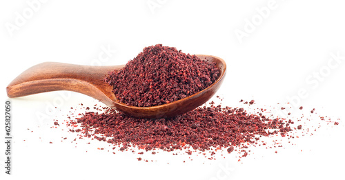 Ground sumac spice pile in wooden spoon isolated on a white background photo
