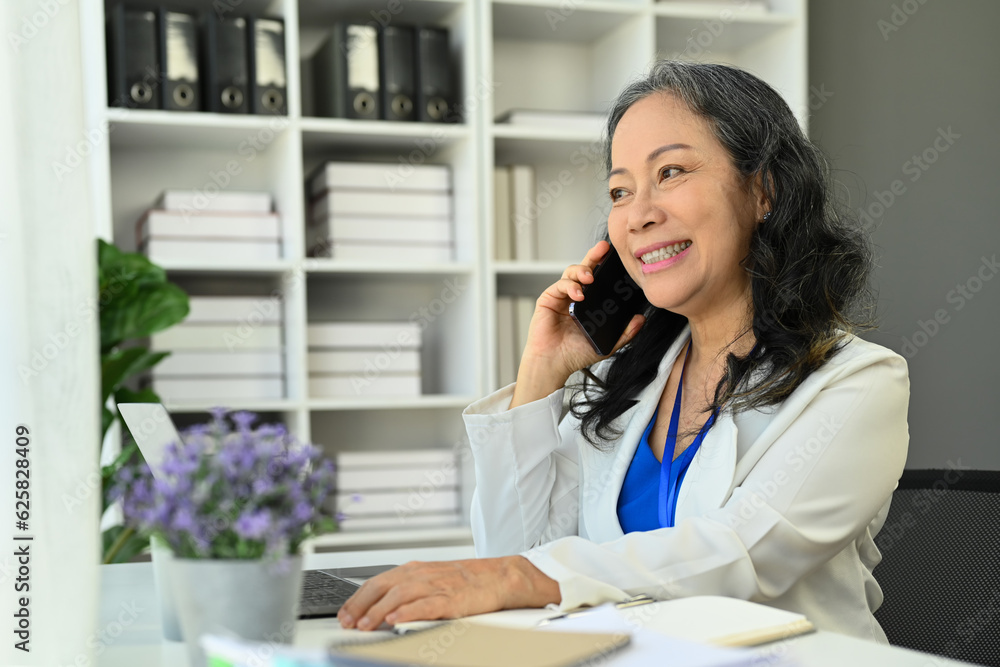Professional investment advisor giving consultation on financial operations to her client via mobile phone Professional investment advisor giving consultation on financial operations to her client via mobile phone