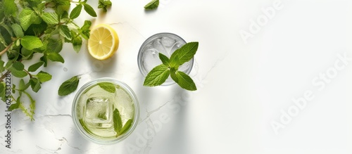Photo of a refreshing glass of green tea with lemon slices and fresh leaves with copy space