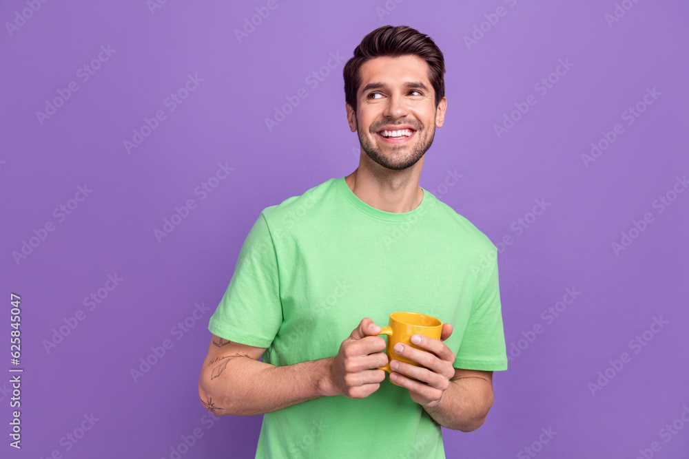 Photo of dreaming funny office manager guy coffee break hold cup looking empty space interested teatime isolated on purple color background Photo of dreaming funny office manager guy coffee break hold cup looking empty space interested teatime isolated on purple color background