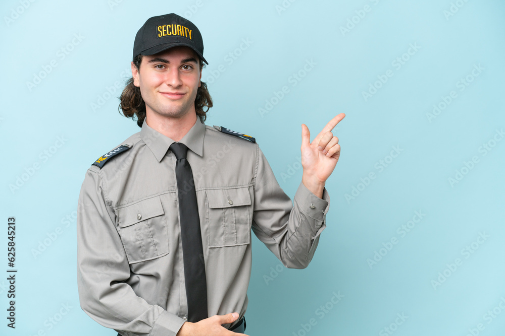 Young safeguard man isolated on blue background pointing finger to the side Young safeguard man isolated on blue background pointing finger to the side