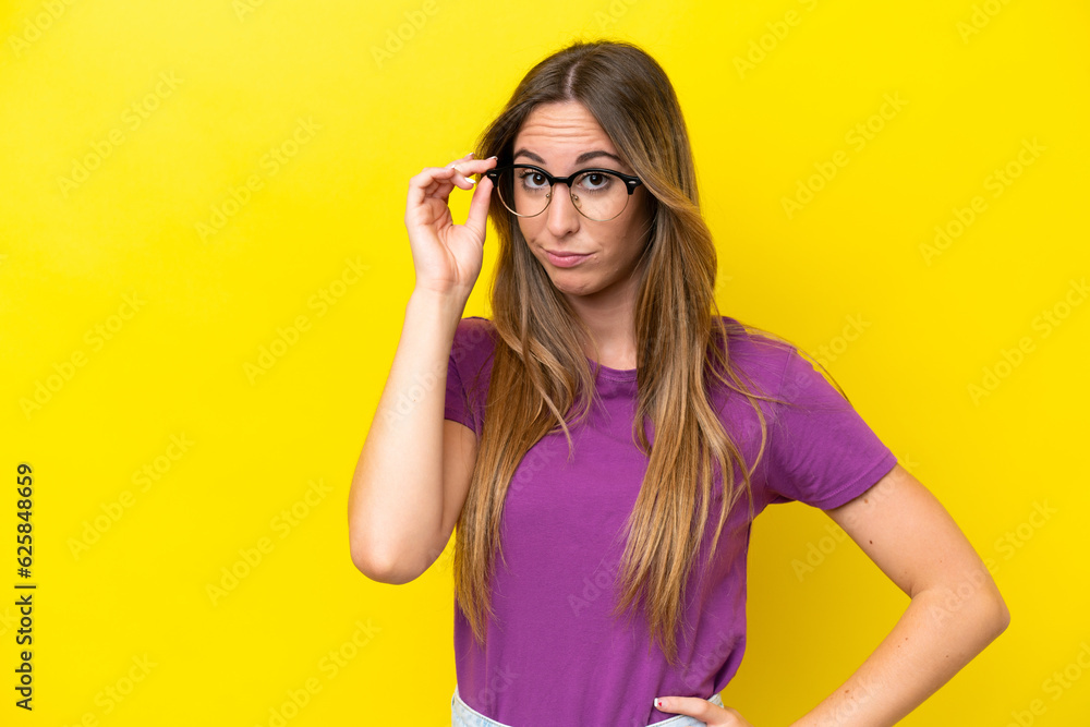 Young caucasian woman isolated on yellow background With glasses and frustrated expression Young caucasian woman isolated on yellow background With glasses and frustrated expression