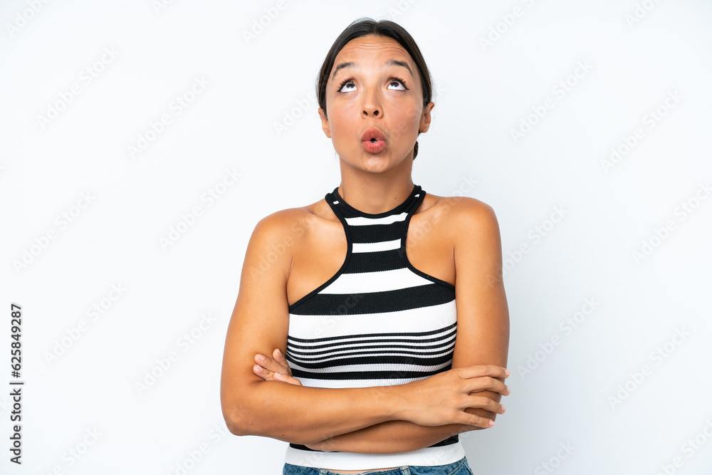 Young hispanic woman isolated on white background looking up and with surprised expression