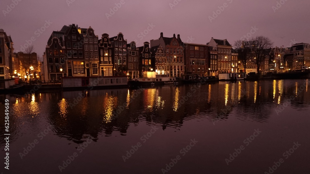 Pink and purple dawn light over the canal houses in Amsterdam
