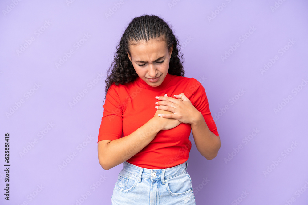 Young woman isolated on purple background having a pain in the heart Young woman isolated on purple background having a pain in the heart