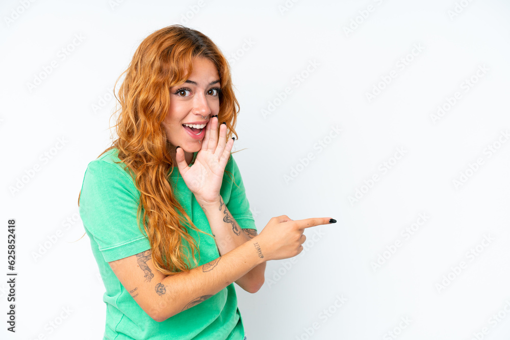 Young caucasian woman isolated on white background pointing to the side to present a product and whispering something Young caucasian woman isolated on white background pointing to the side to present a product and whispering something