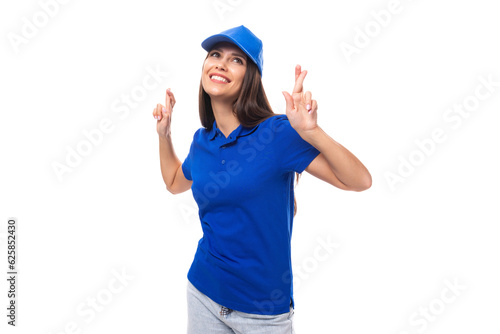 active young brunette woman promoter in blue t-shirt and cap on white background with copy space