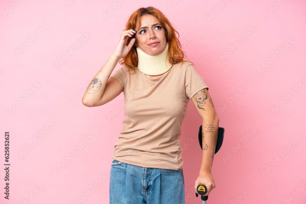 Young caucasian woman wearing neck brace isolated on pink background having doubts and thinking