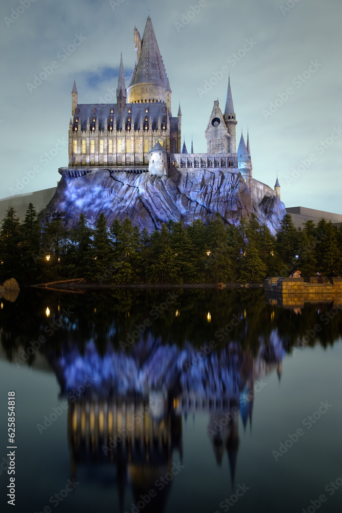 Naklejka premium OSAKA, JAPAN - 02022023: Universal Studios Japan . The Hogwarts castle reflect to the water in The Wizarding World of Harry Potter in Universal Studio Osaka