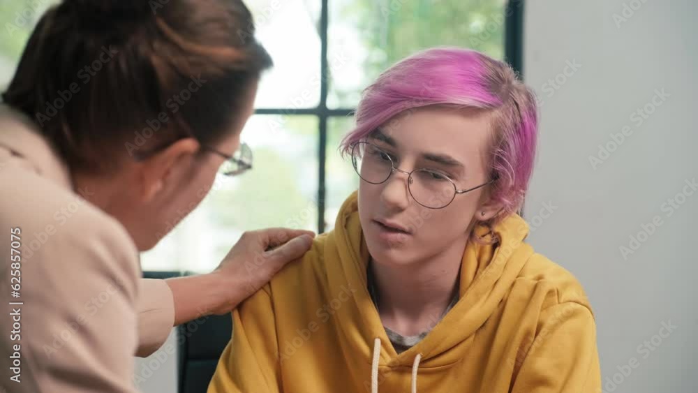 Over the shoulder shot, psychologist supporting male teenager while he talks about his problems at school during consultation at office Over the shoulder shot, psychologist supporting male teenager while he talks about his problems at school during consultation at office