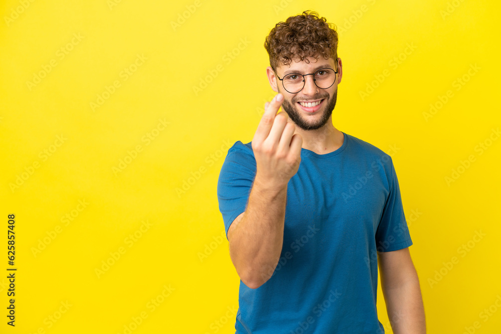 Young handsome caucasian man isolated on yellow background making money gesture Young handsome caucasian man isolated on yellow background making money gesture