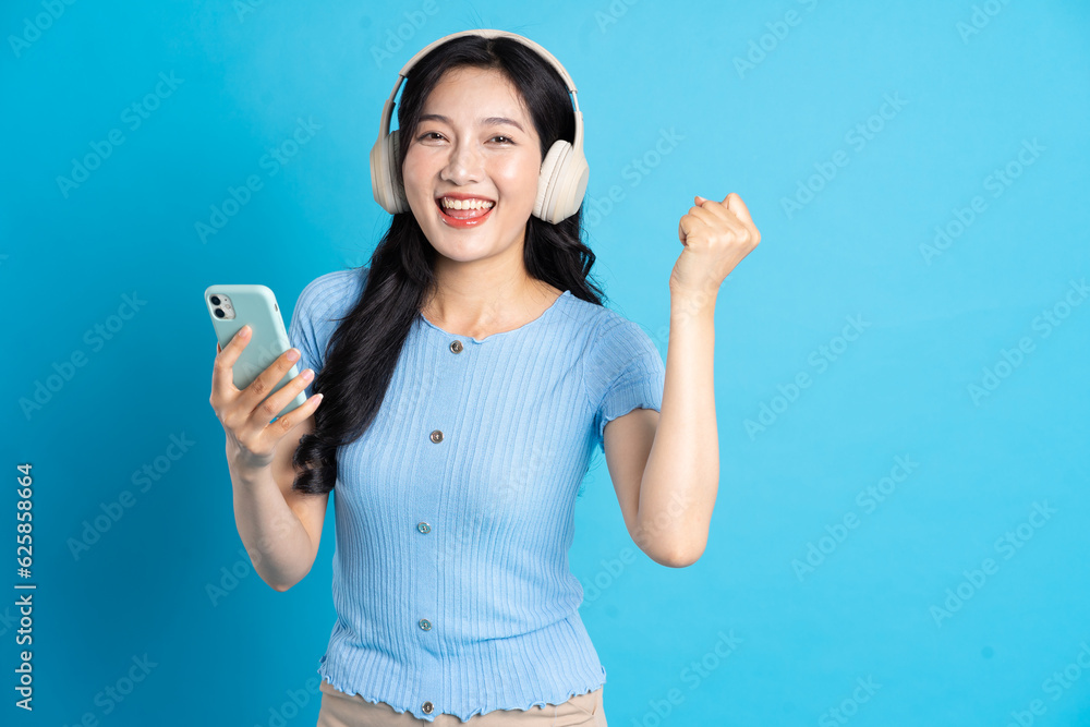 Portrait of smiling asian woman posing on blue background Portrait of smiling asian woman posing on blue background