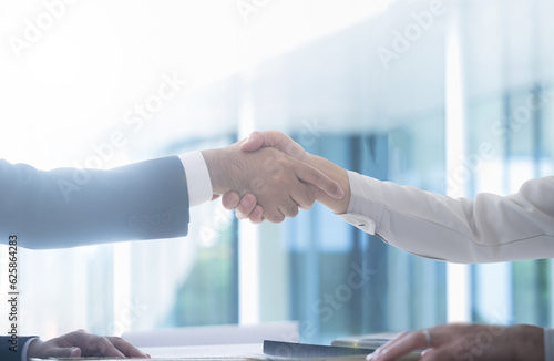 Man in suit and man in work clothes shaking hands in business Contract scene, etc.