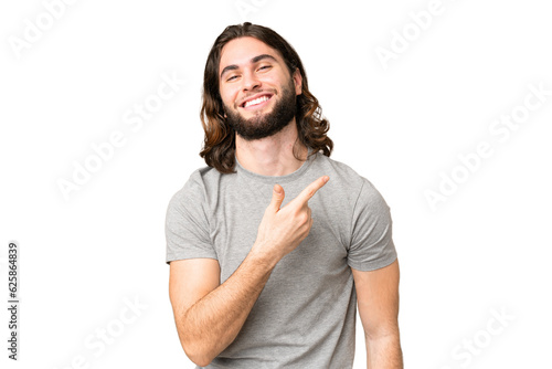Young handsome man over isolated chroma key background pointing to the side to present a product